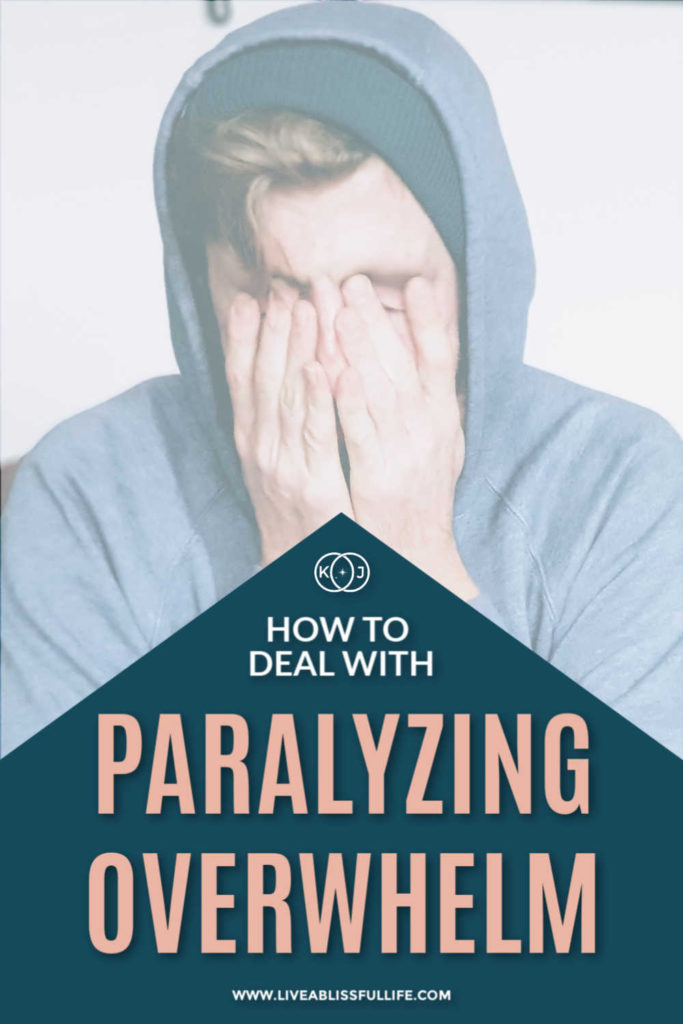 text: how to deal with paralyzing overwhelm
image: man in blue sweater covering his face with both hands