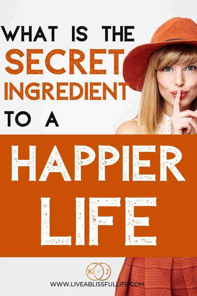 image: woman in bright orange dress and hat with her finger against her lips
text: what is the secret ingredient to a happier life
